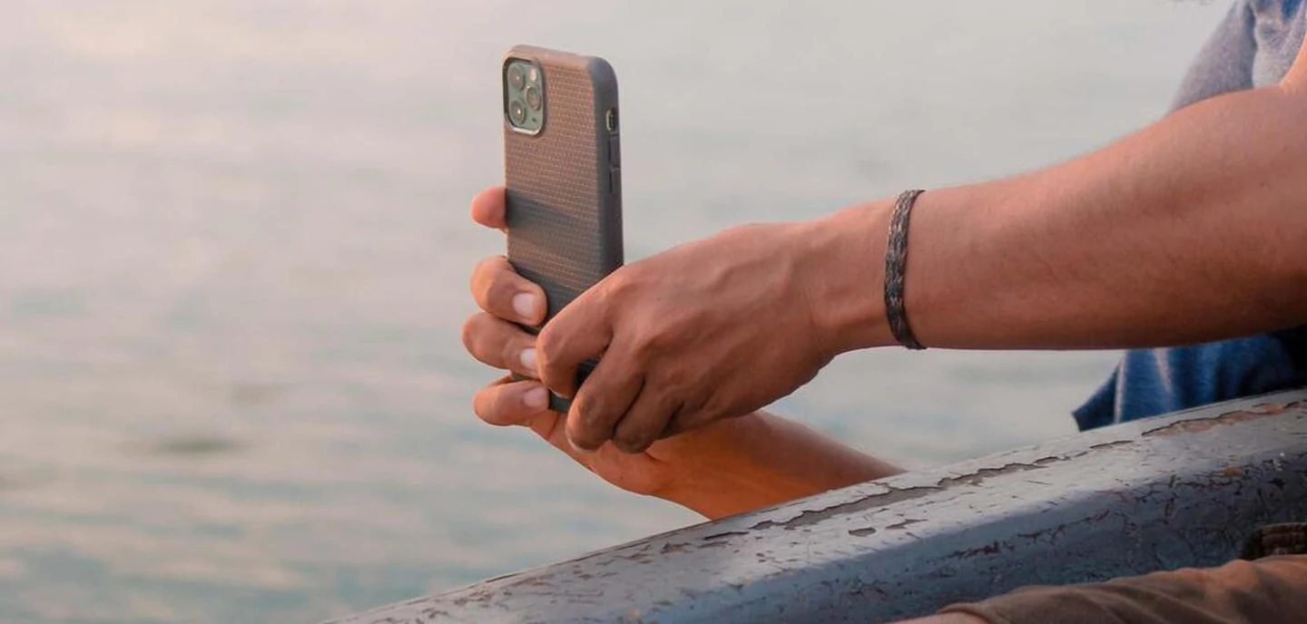 man taking a photo of sunset with iphone