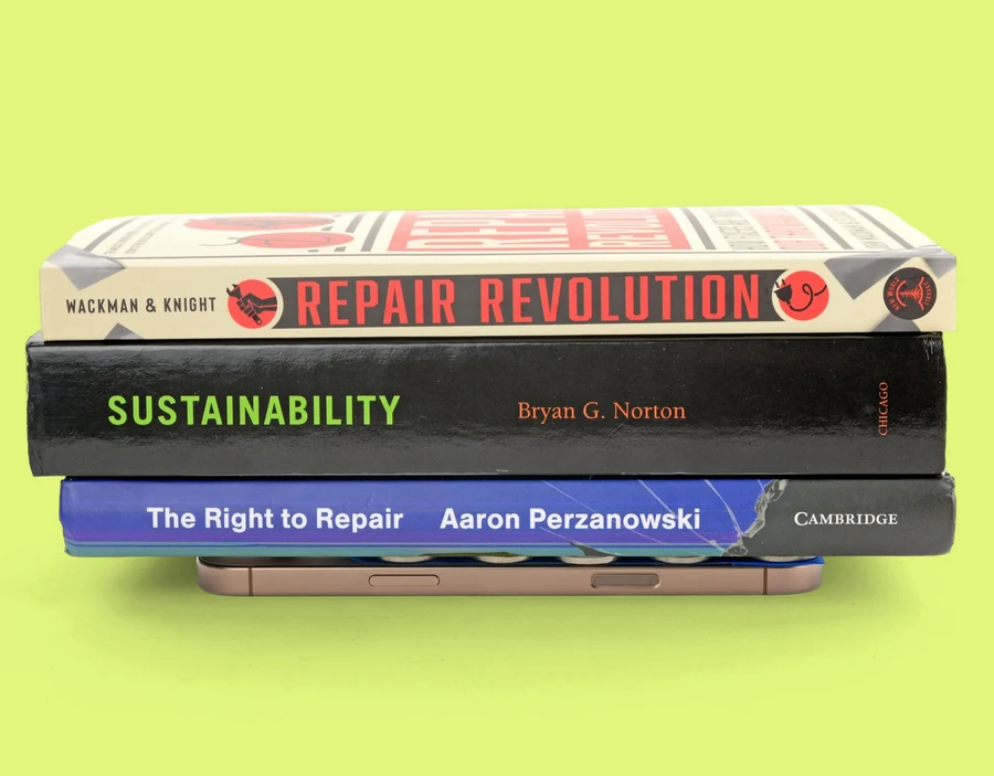 An iPhone facedown with a book on top of it