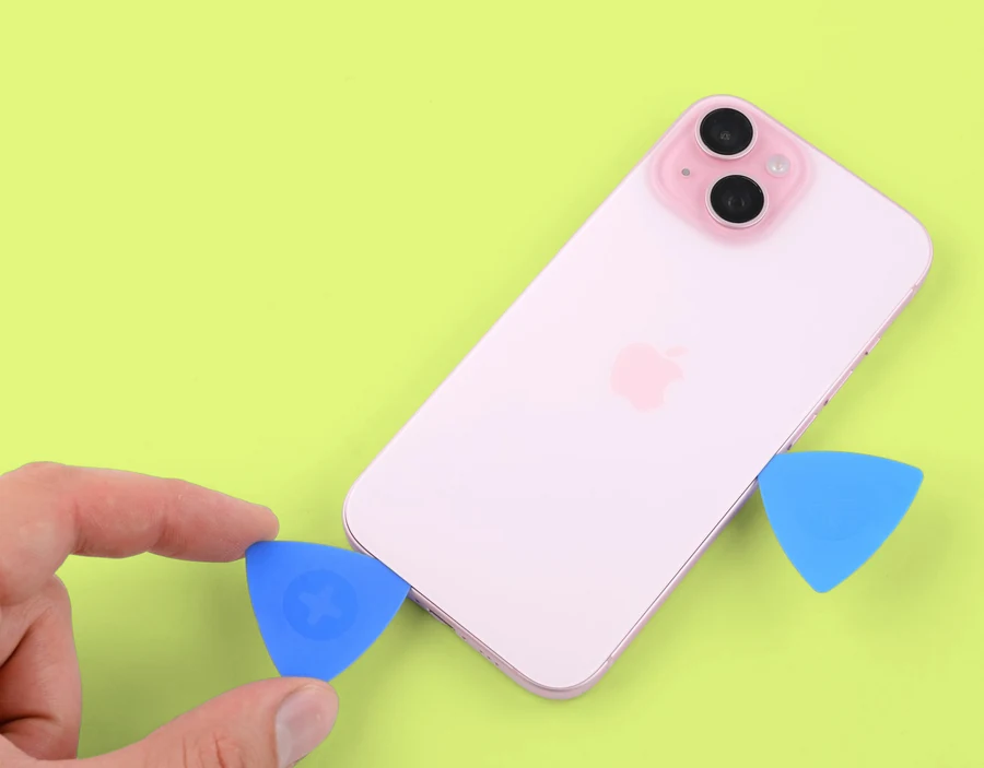 An image of an iPhone screen with several picks inserted beneath the screen