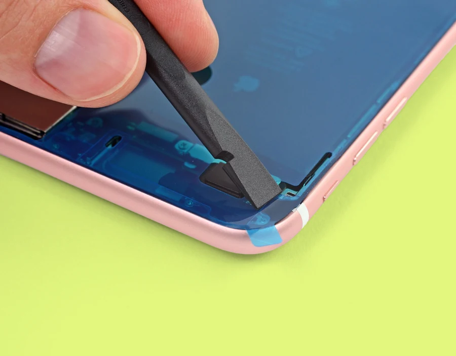 An iPhone with the screen removed and tweezers pulling off the adhesive